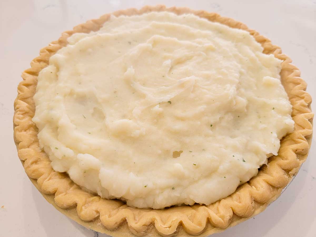 cottage pie filling topped with mashed potatoes in a pie crust.
