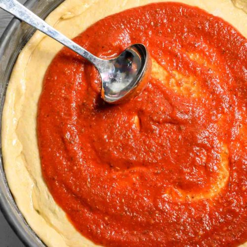 5 Minute Pizza Sauce spread on pizza dough.