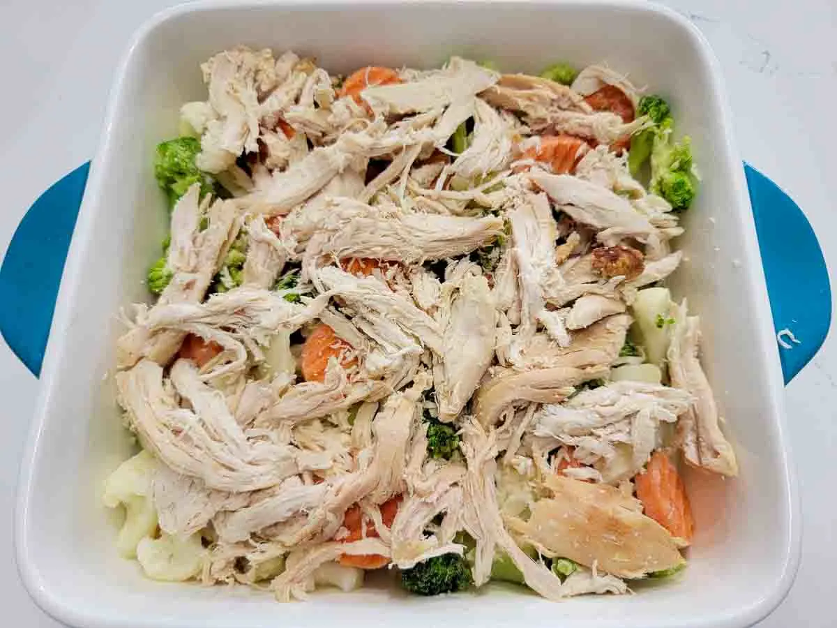 mixed vegetables and rotisserie chicken in a casserole dish.