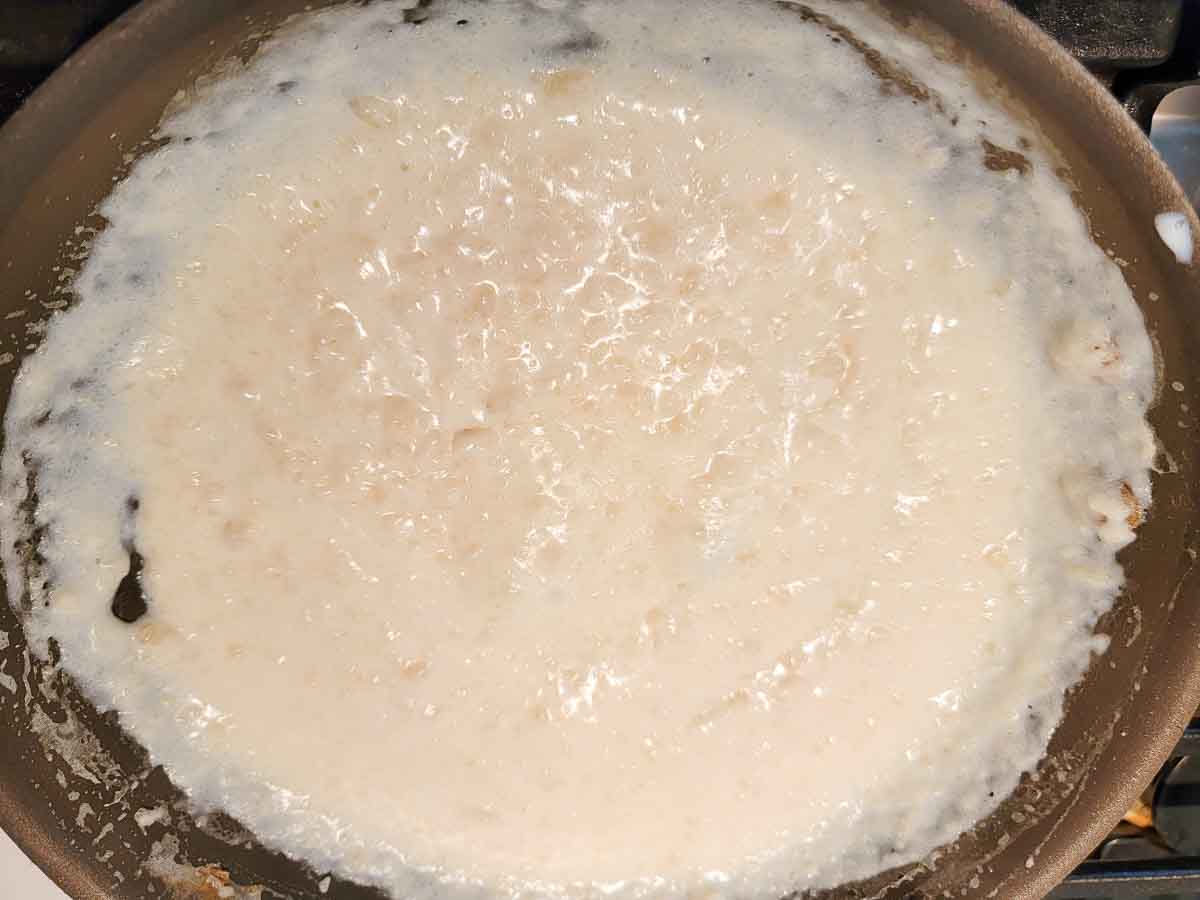 butter, flour, and milk cooking in a pan.