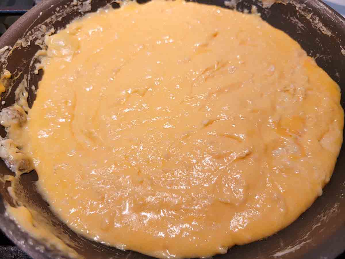 cheese sauce cooking in a pan.