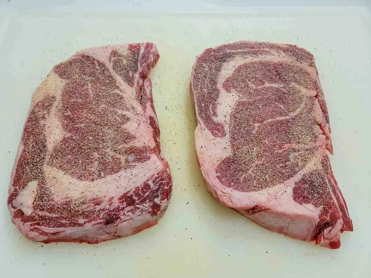 ribeye steaks evenly sprinkled with salt, pepper, garlic powder, and onion powder.