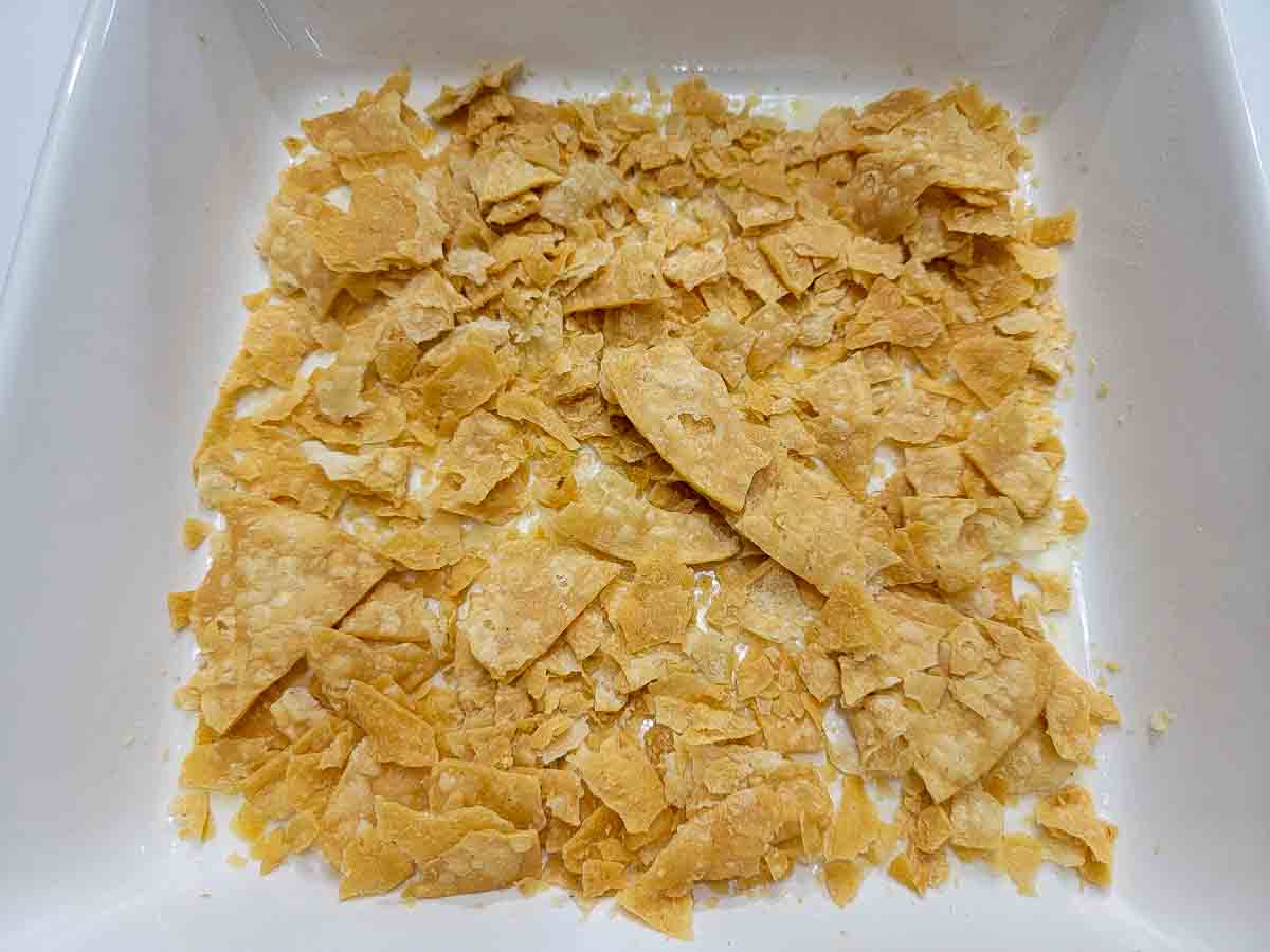 crushed tortilla chips in the bottom of a casserole dish.