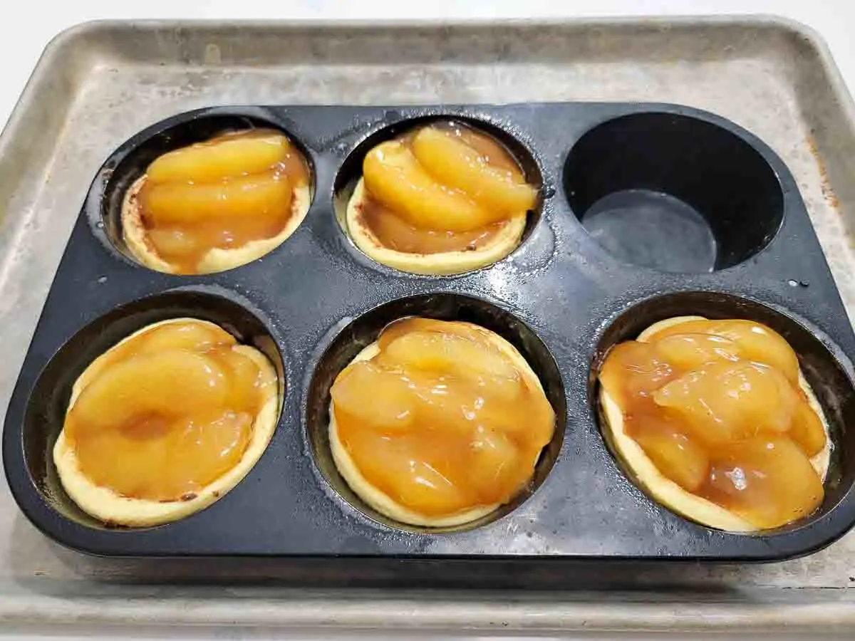 apple pie filling and jumbo cinnamon rolls pressed into a jumbo muffin pan.