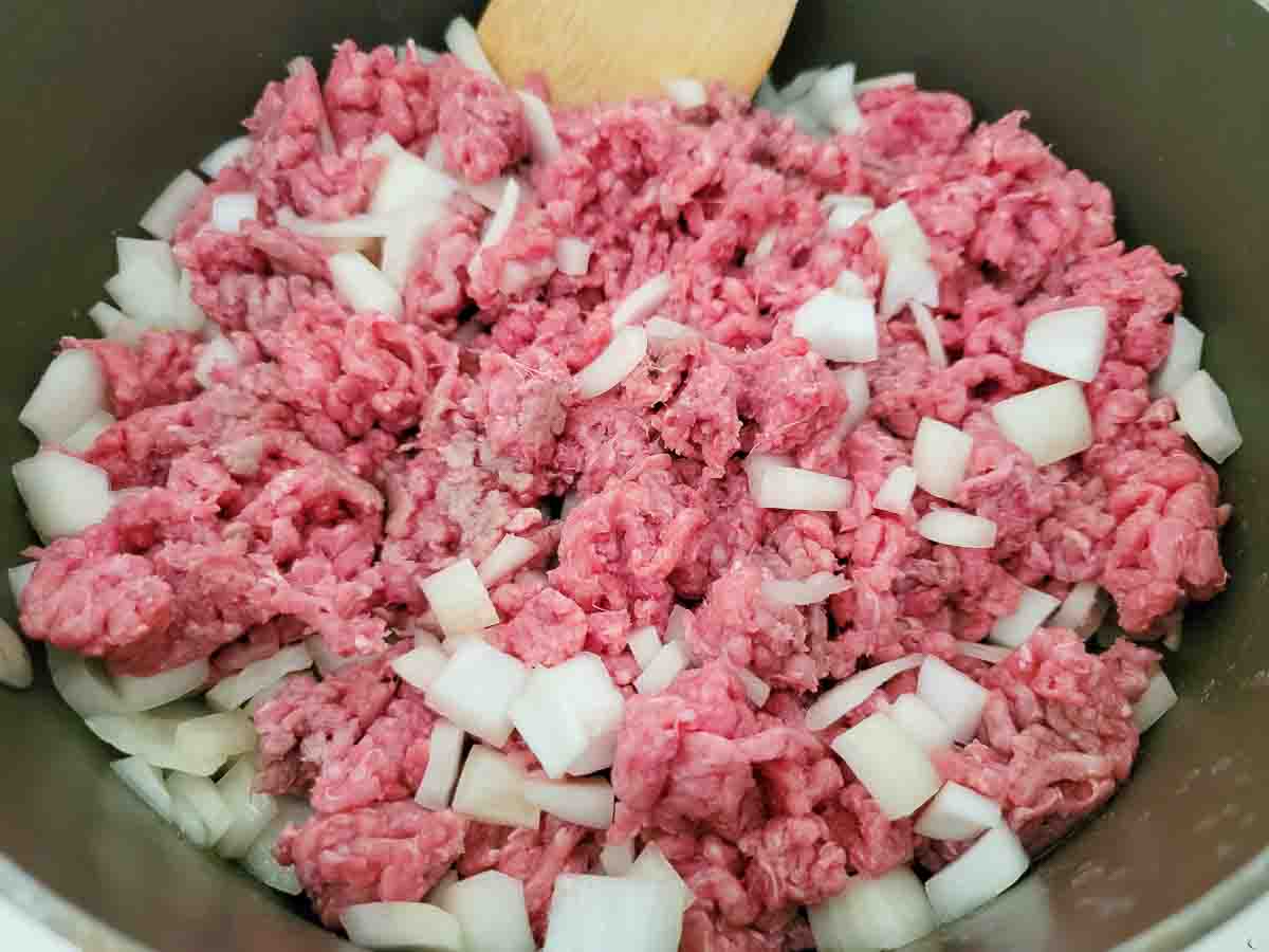 ground beef and onions cooking in a pan.